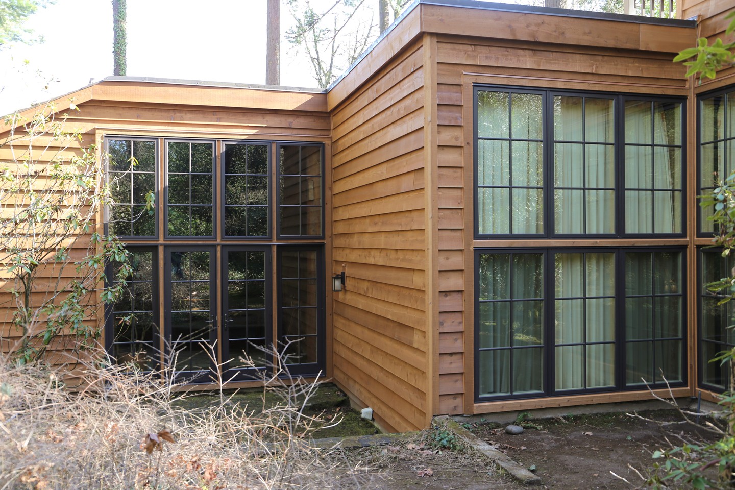 Cedar channel siding and large windows on a Northwest contemporary home in the Portland area