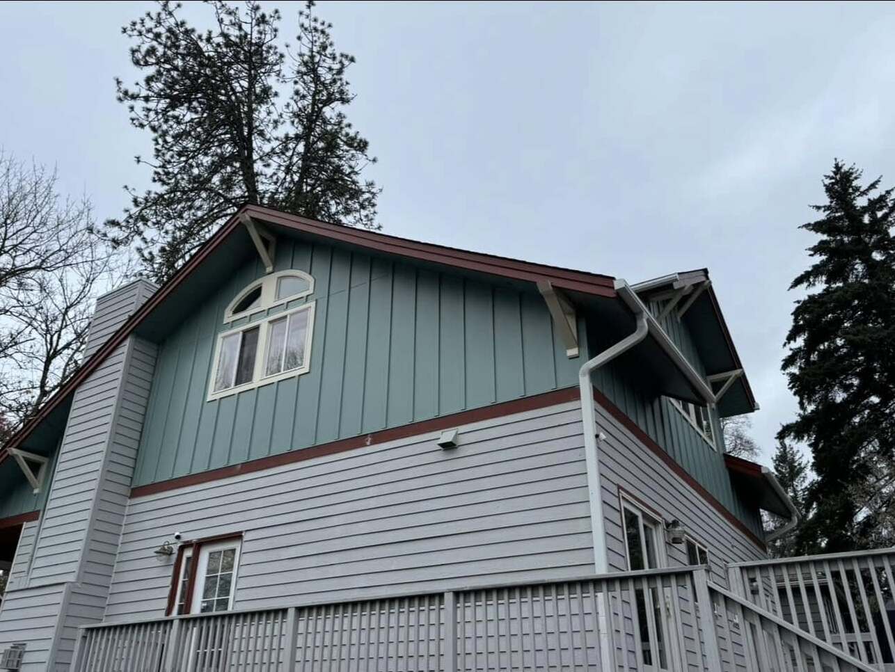 Completed siding repair with new boards and matching paint on a two-story Portland home